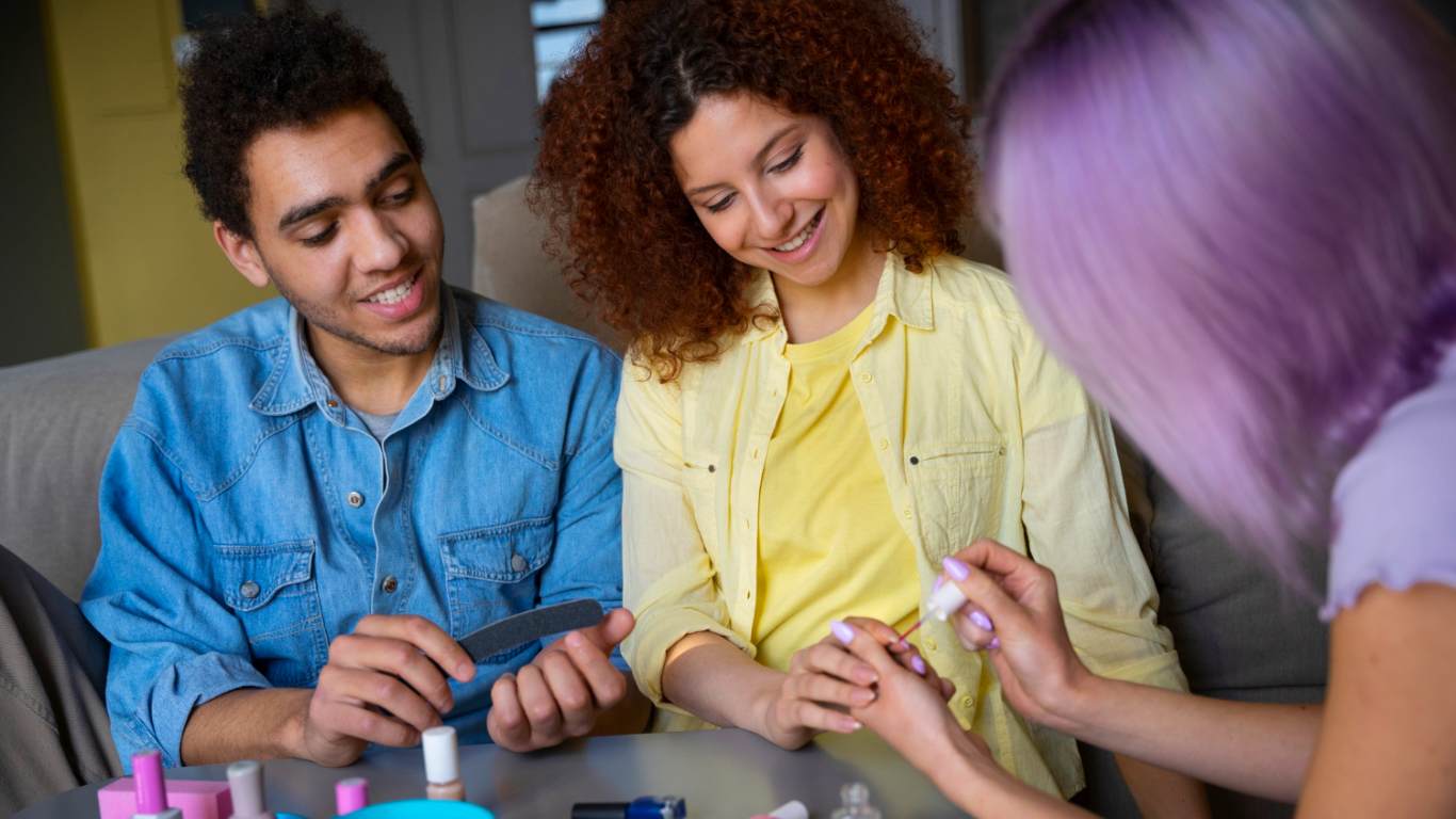 imagem de três jovens da Geração Z brincando de pintar a unha um do outro