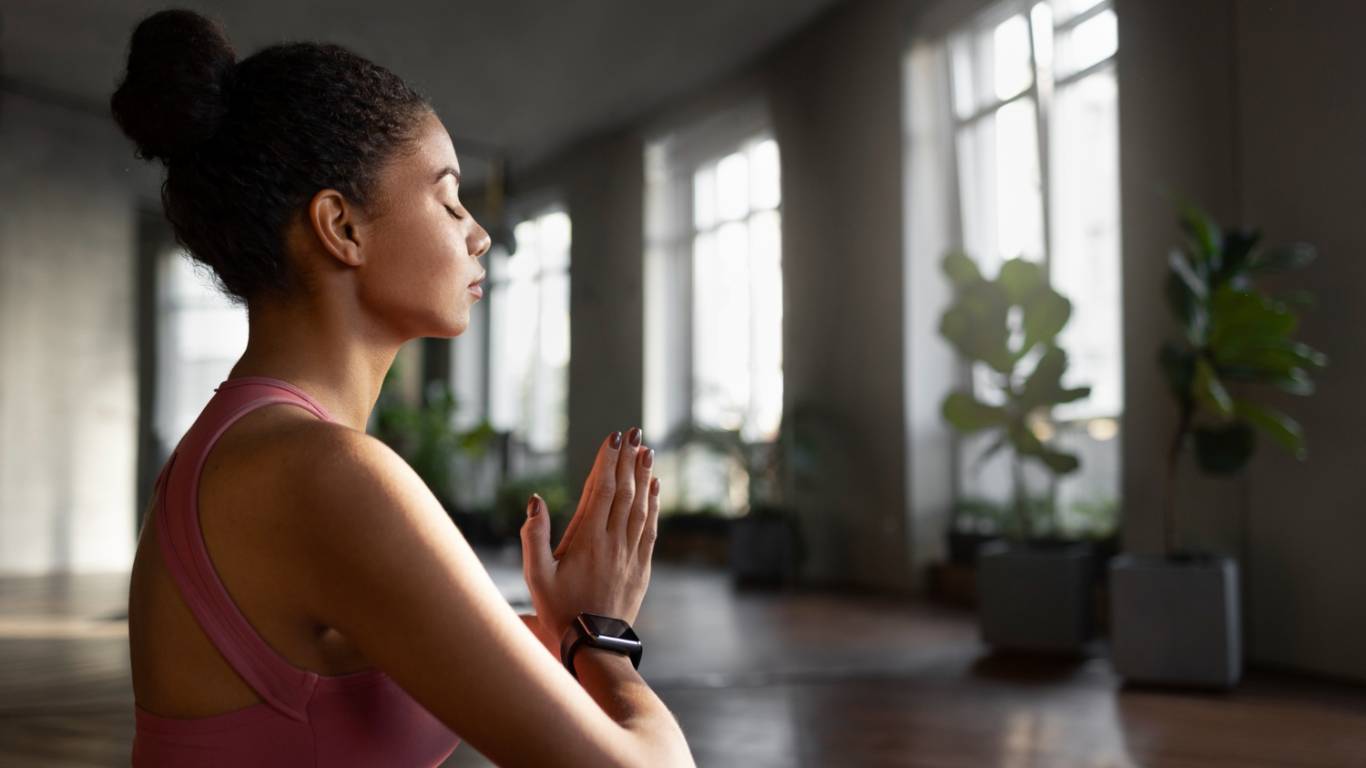 imagem de uma moça sentada meditando
