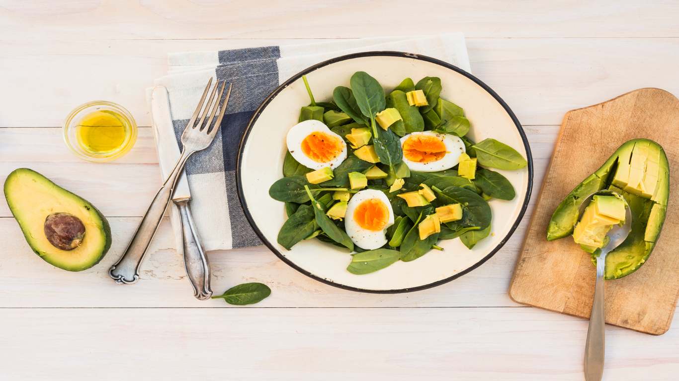 imagem de alimentos que fazem parte de uma dieta cetogênica, como abacate, ovo e folhas verdes