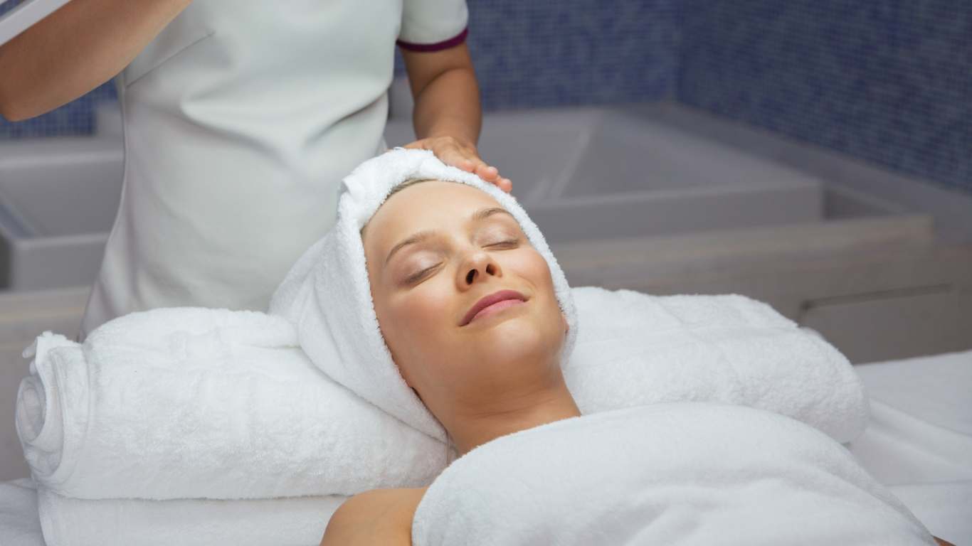 Mulher deitada na sala de massagem de face para cima