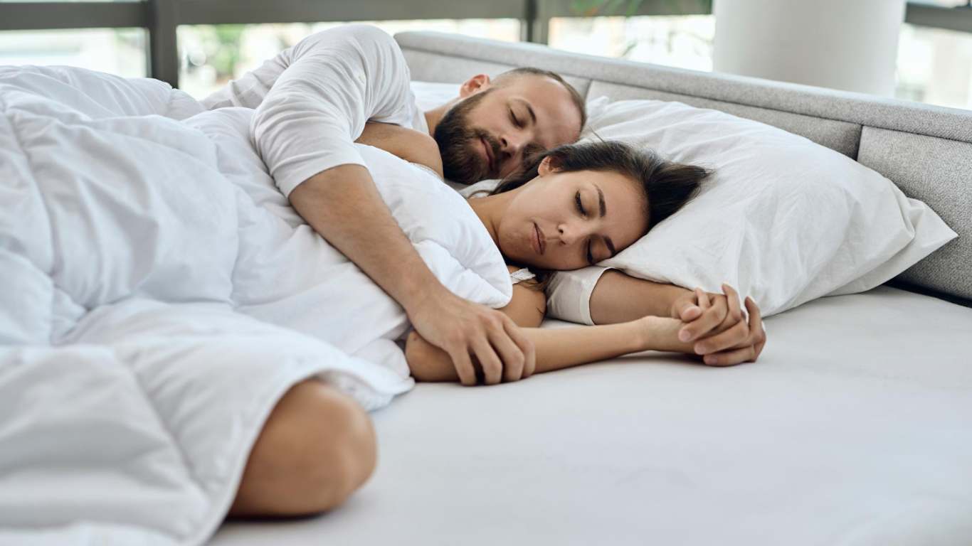 imagem de um casal dormindo de conchinha