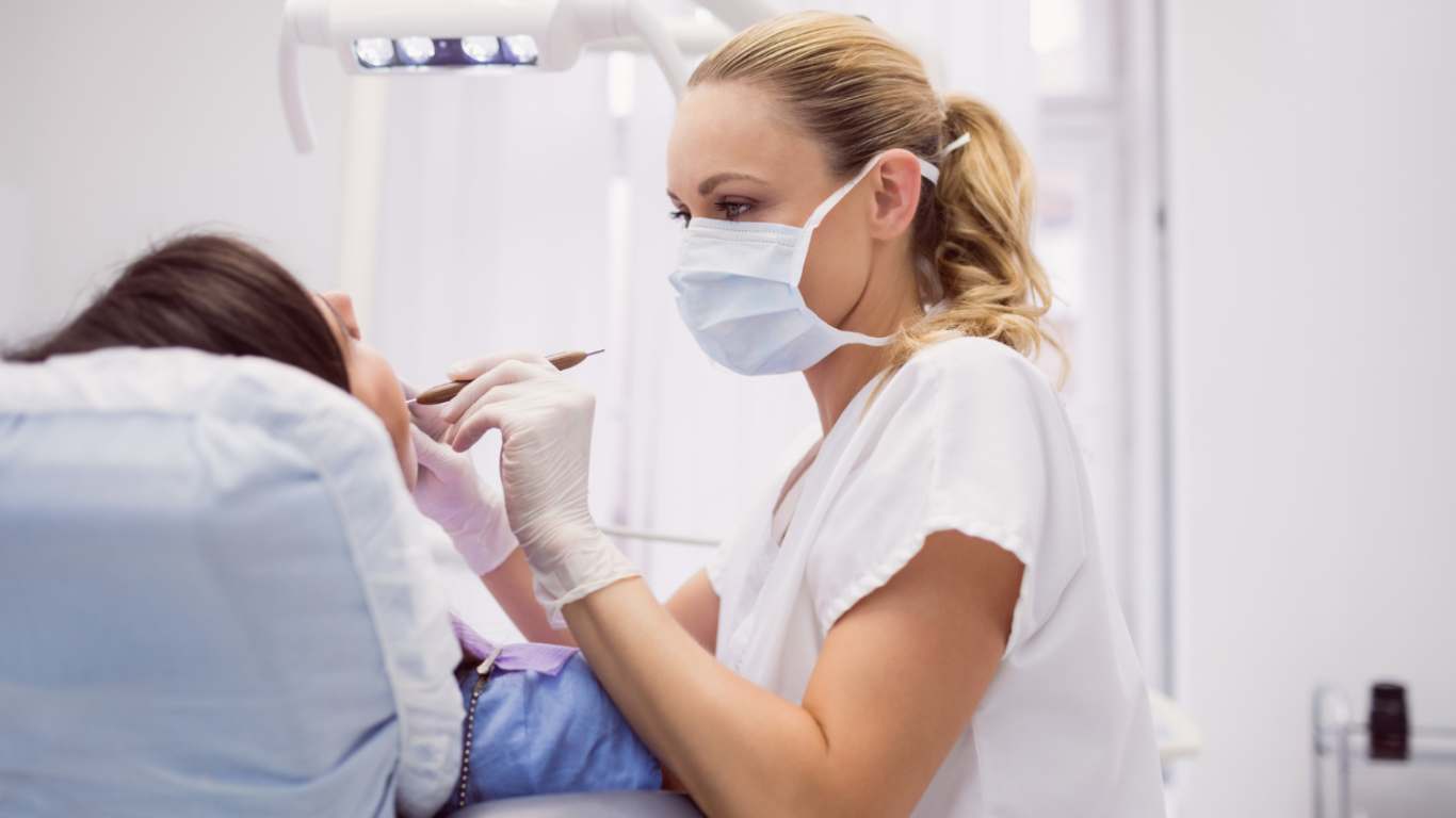 imagem de uma dentista colocando implantes dentários em uma paciente