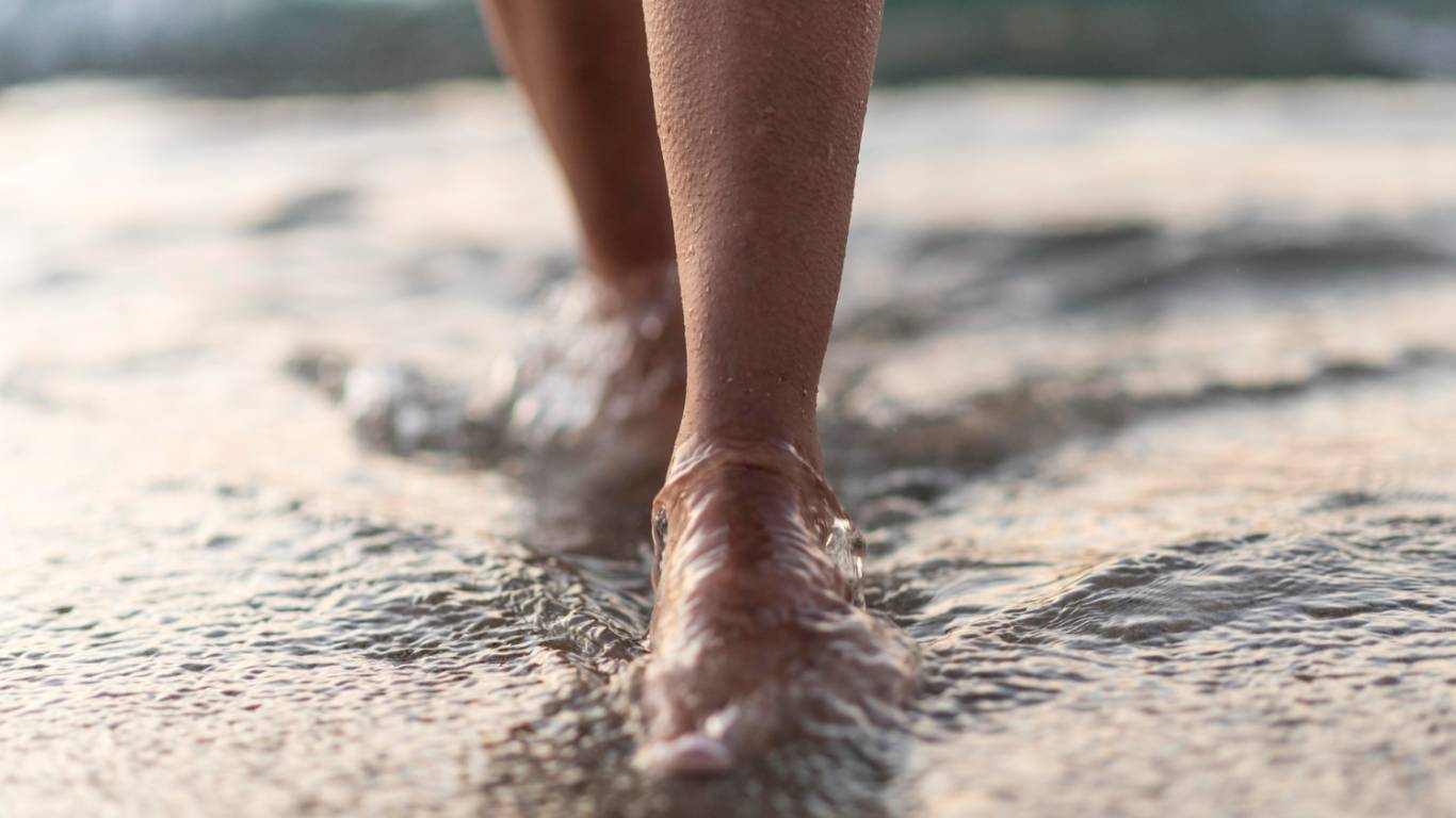 imagem de uma mulher andando no mar em alusão à trocar a era da performance por presença