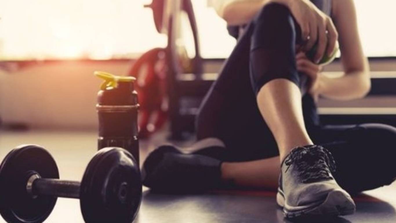 imagem de uma moça sentada no chão depois de treinar