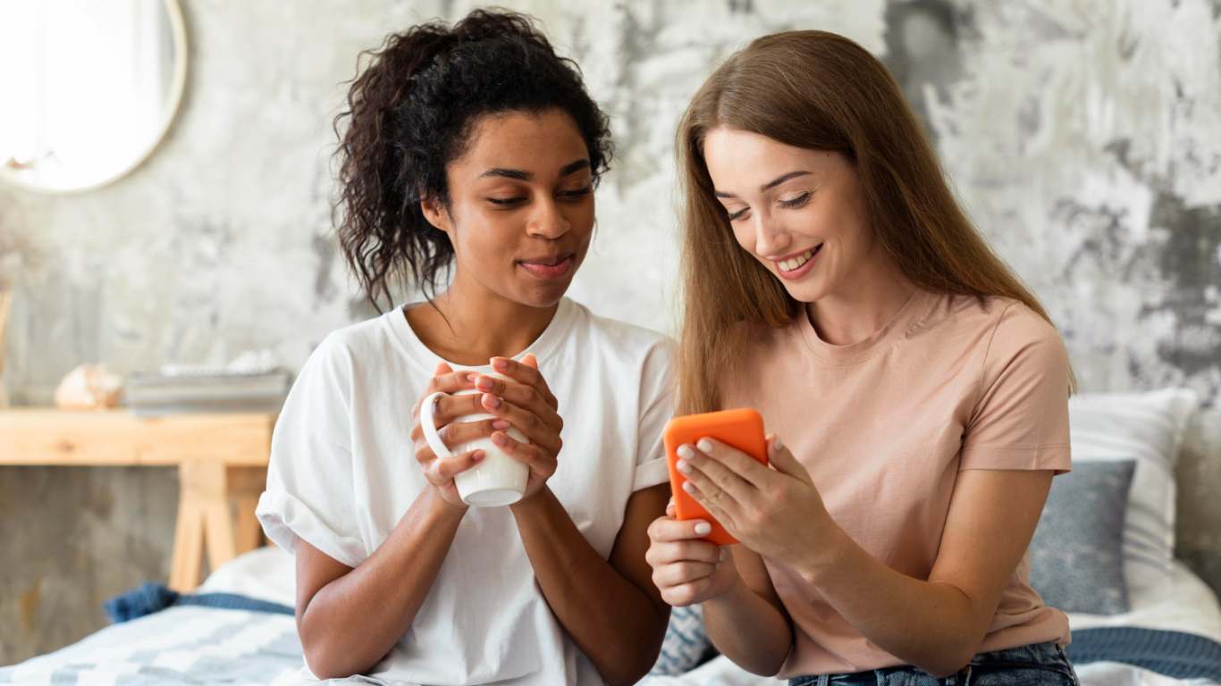 imagem de duas amigas olhando o celular