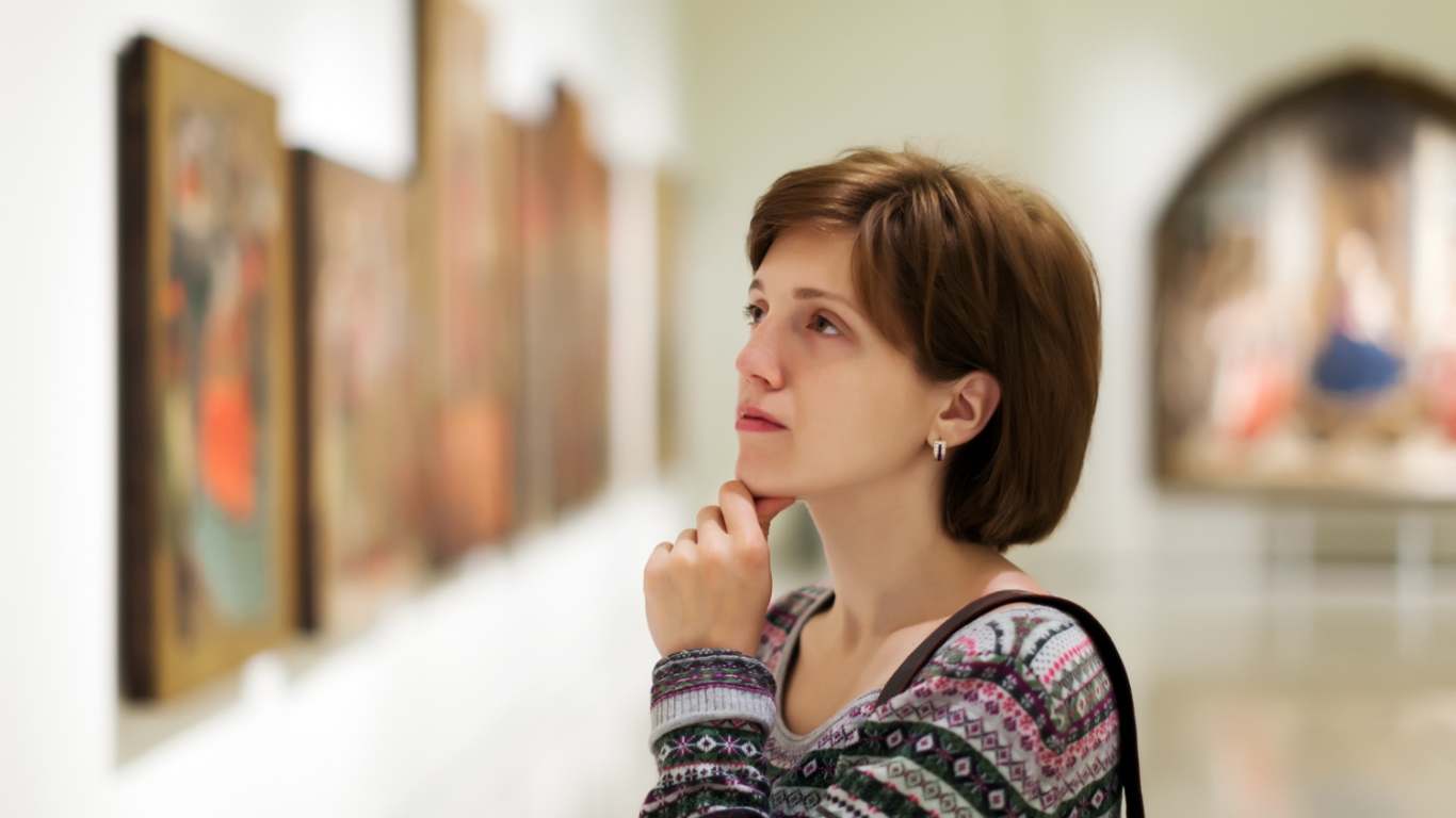 imagem de uma mulher olhando uma arte em uma galeria de arte