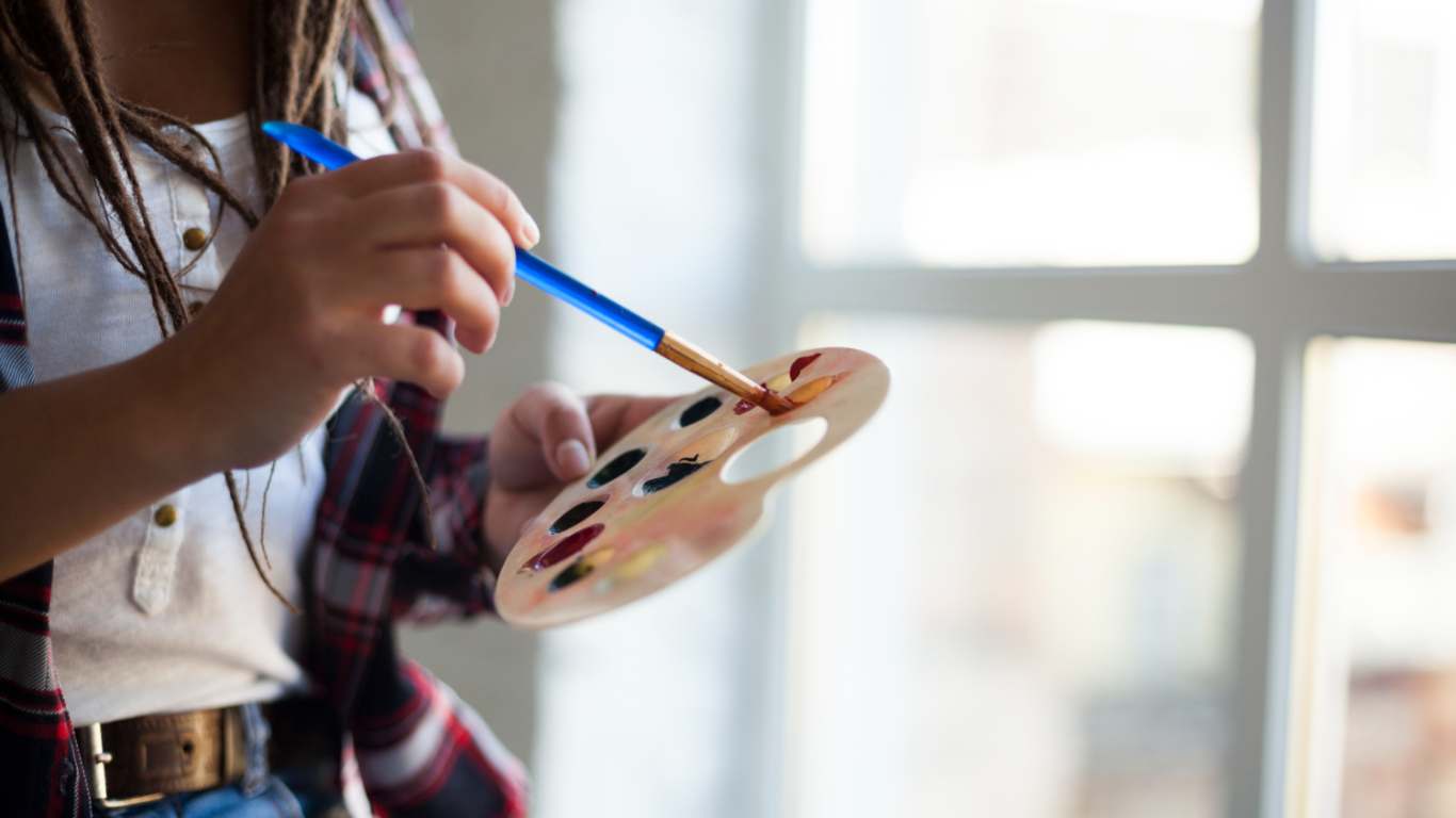 imagem de uma mulher aproveitando um dos seus hobbies que é pintar