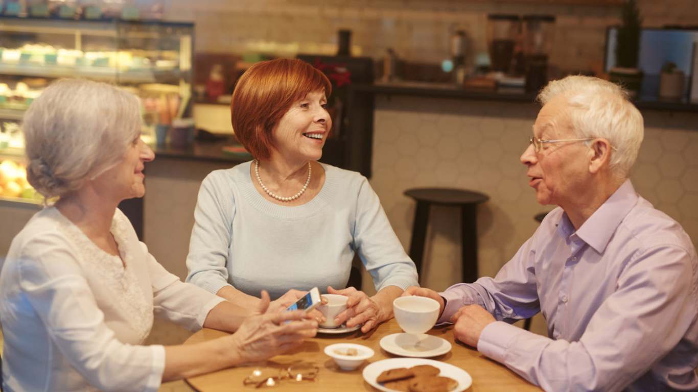imagem de três idosos tomando um café