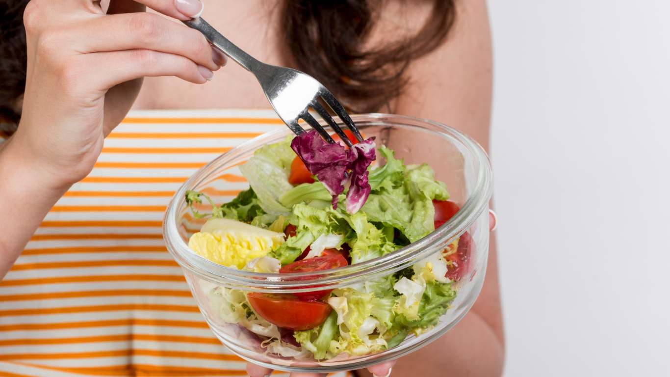 imagem de uma mulher comendo salada