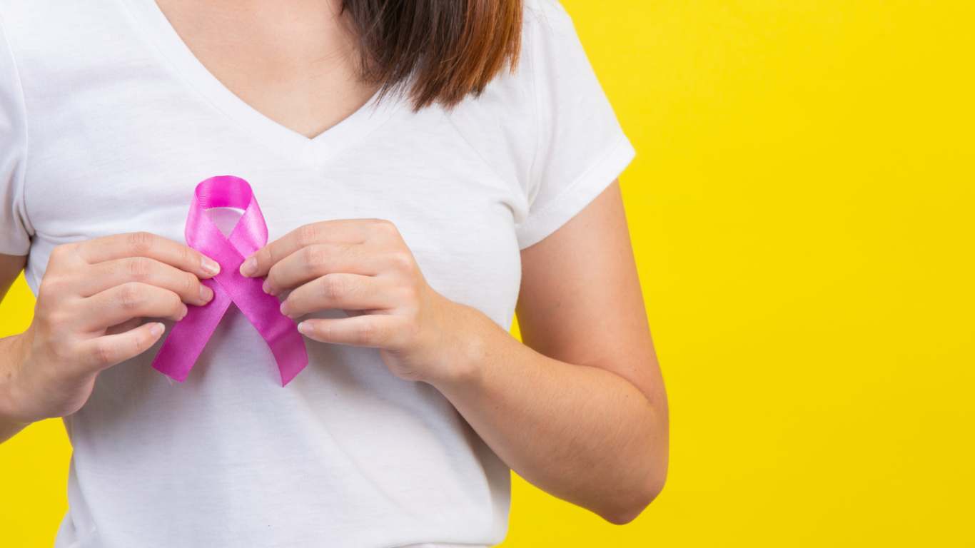 imagem de uma moça segurando o laço rosa do Outubro Rosa