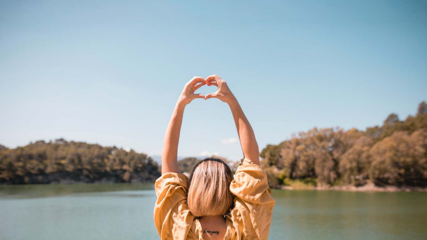 imagem de uma mulher fazendo coração com a mão