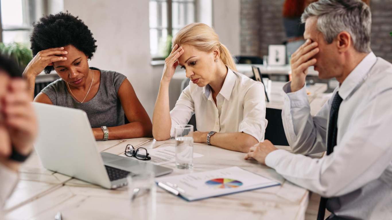 imagem de três profissionais cansados mentalmente