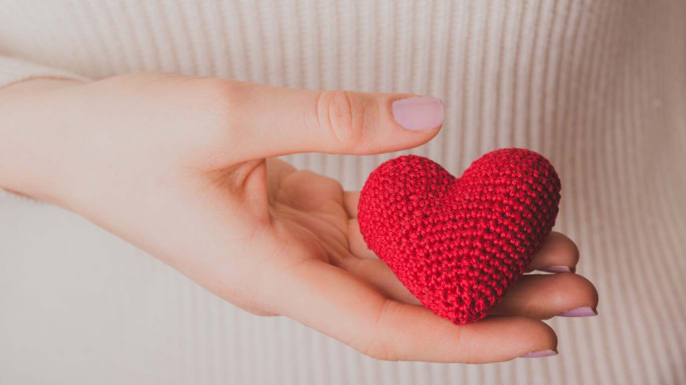imagem de uma moça segurando um coração de pelúcia