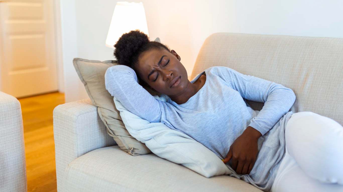 imagem de uma moça sofrendo com cólica