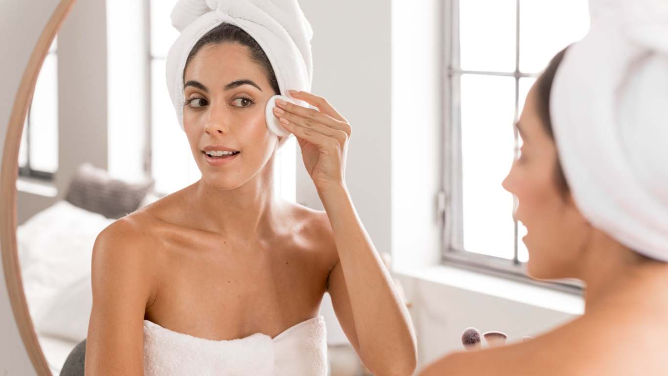 imagem de uma moça fazendo skincare no espelho