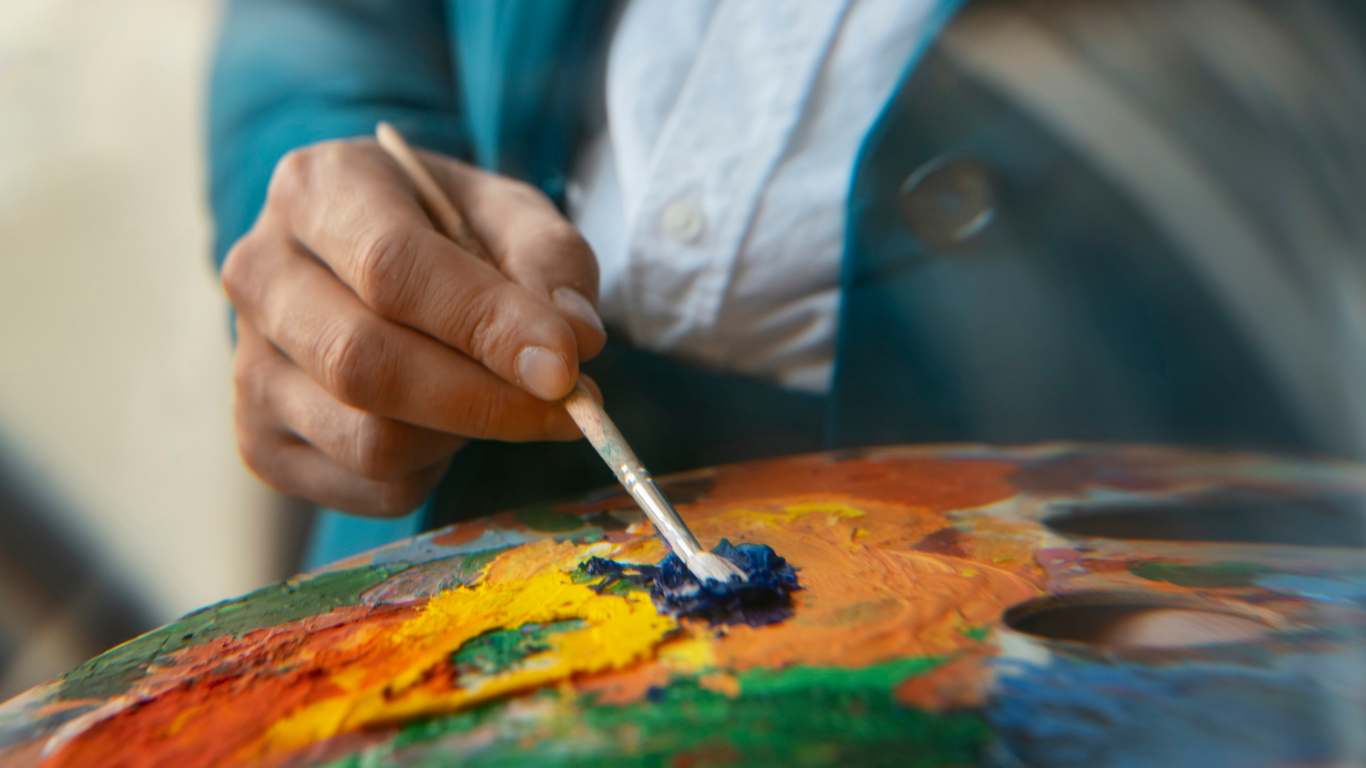 imagem de um homem pincelando uma paleta de tinta