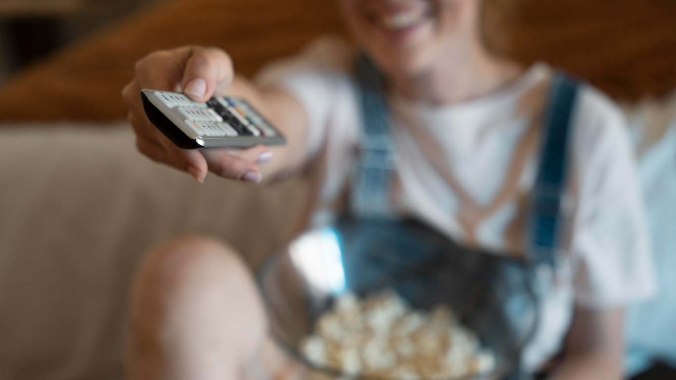 imagem de uma mulher ligando a tv para ver série