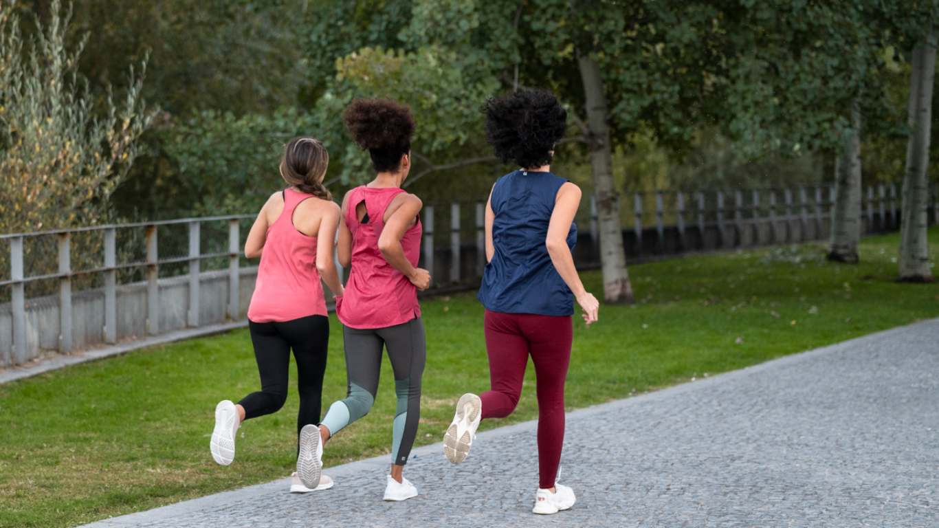imagem de três amigas correndo no parque