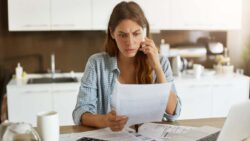 imagem de uma moça fazendo cálculos e vendo que está com falta de dinheiro