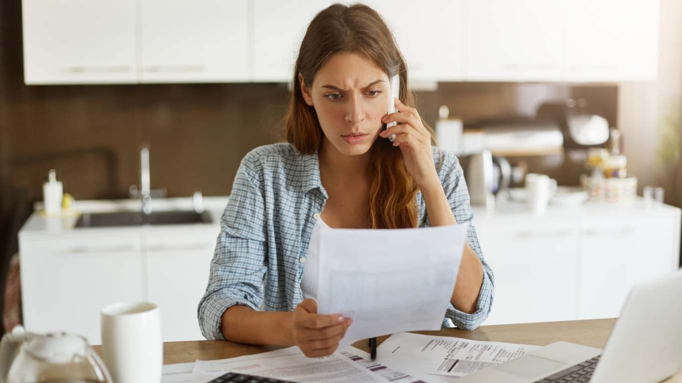 imagem de uma moça fazendo cálculos e vendo que está com falta de dinheiro