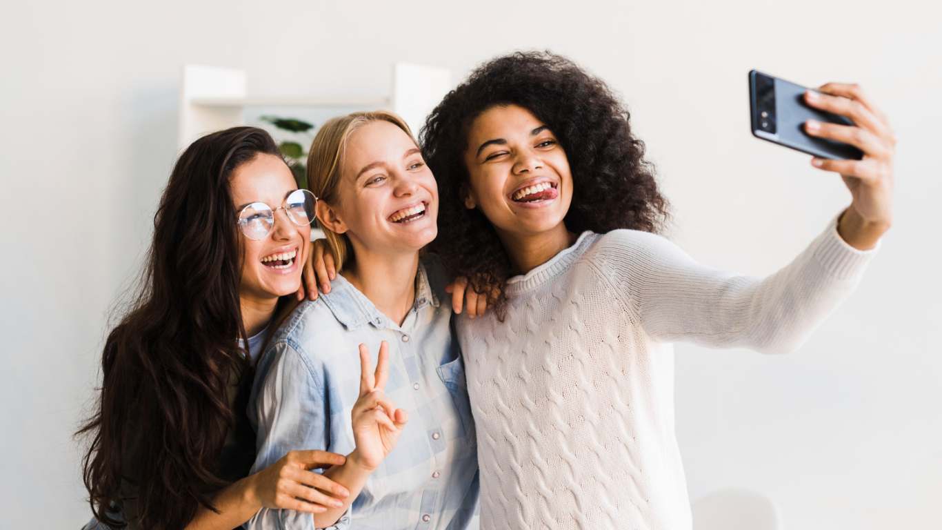 imagem de tres amigas tirando selfie