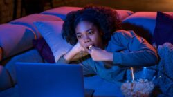 imagem de uma moça comendo pipoca e vendo filme