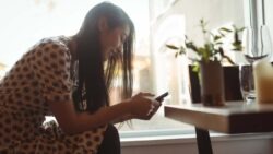 imagem de uma moça olhando pro celular