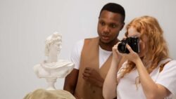 imagem de um casal no museu olhando uma arte