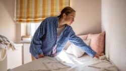 imagem de uma moça arrumando seu quarto