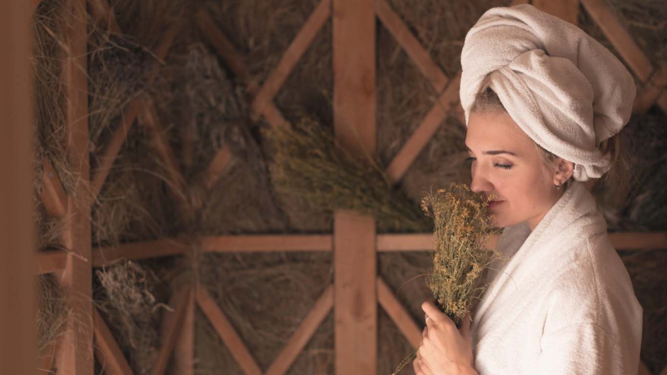 imagem de uma moça cheirando uma erva para fazer banho