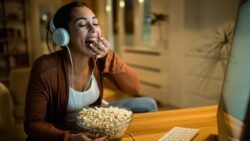 imagem de uma moça comendo pipoca e vendo série